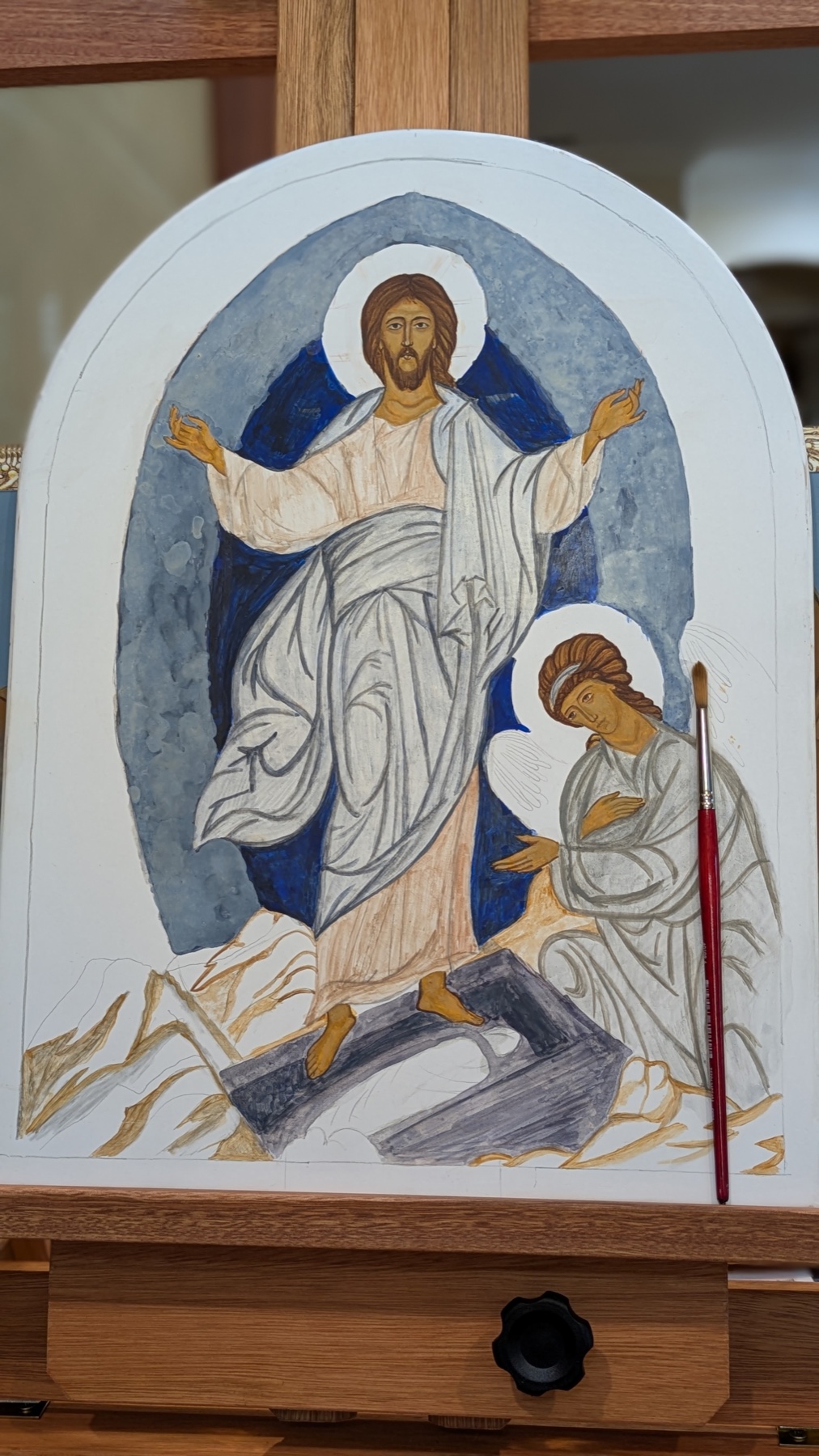 The Resurrection icon in progress on studio easel with artist paintbrush